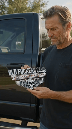 Man holding chrome-look OLD F*CKERS CLUB emblem next to truck tailgate